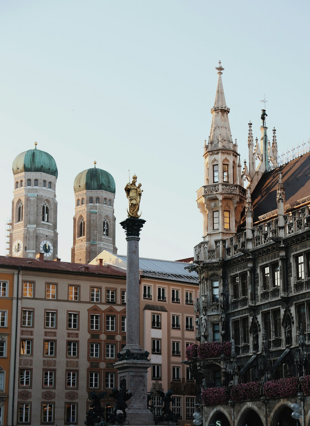 a-statue-in-front-of-a-building-with-a-clock-tower-in-the-background-1x5bt6stxxi